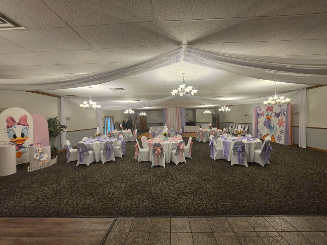 Houston Hall dressed for a baby shower — ceiling draping, chandeliers, round tables in white, lavender and pink