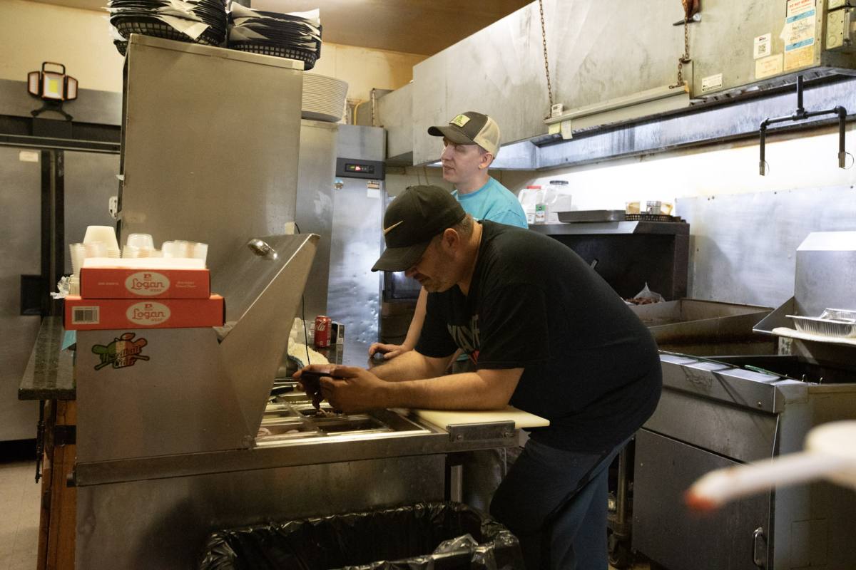 Michael working the line in the Houston Pub kitchen, a second cook plating behind him
