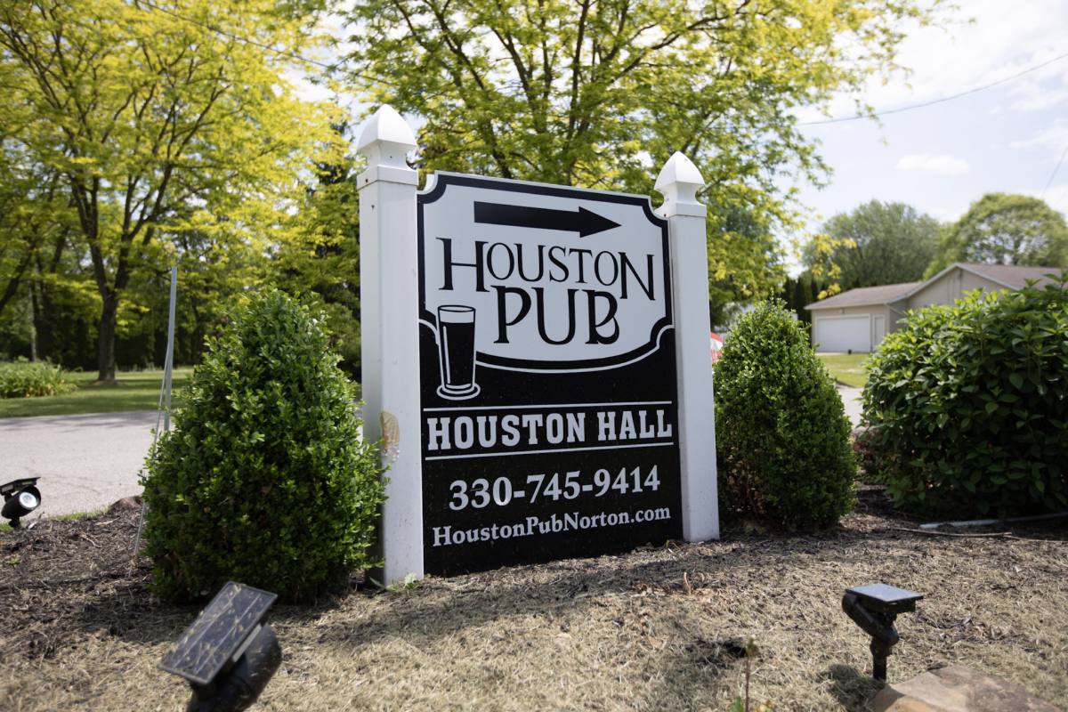 The sign at the road — Houston Pub above Houston Hall, with the phone number and website, framed by boxwoods